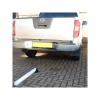 900W-(76), Fold Down Parking Bollard (laying on the ground behind a large vehicle).